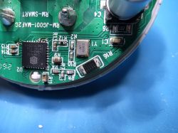 Close-up of a green PCB with an IC chip, SMD resistors, and a capacitor.