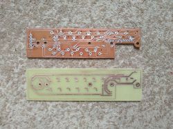 Two printed circuit boards, one darker and one lighter.