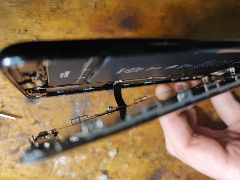 Interior of a Disassembled iPhone Inside view of an opened iPhone showing the battery and ribbons.
