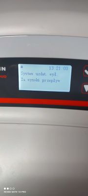 Panel urządzenia z komunikatem System uzdatn. wyl. Za wysoki przepływ.