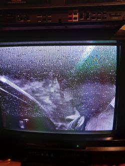 Ekran telewizora z zakłóceniami i magnetowid Goldstar na górze.