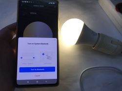 Pairing Tuya Bluetooth Device with App Smartphone pairing a Bluetooth device with Tuya app next to a LED bulb.