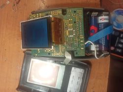 Rozebrane urządzenie elektroniczne z widoczną płytką PCB i zasilaniem bateryjnym