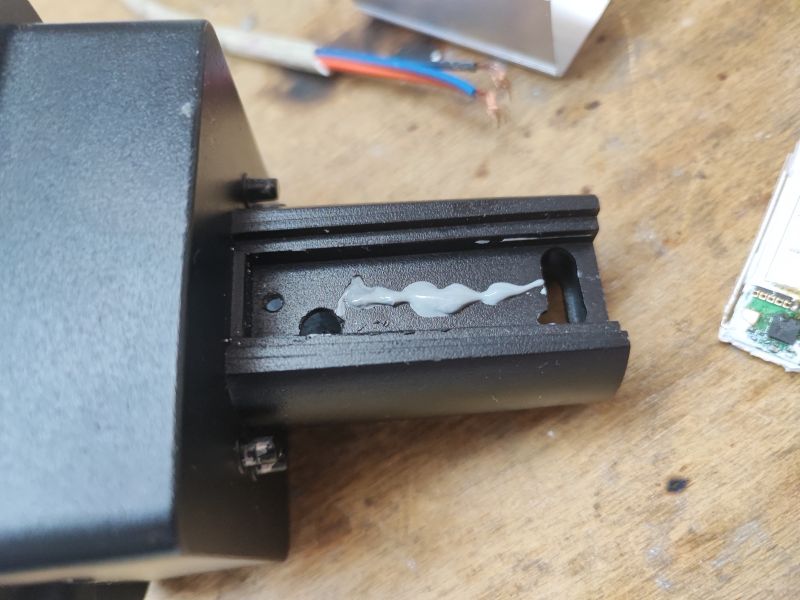 Lamp Housing with Thermal Paste Black lamp housing with a layer of thermal paste on a metal base.