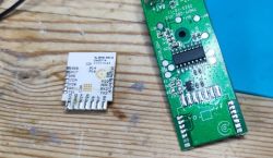 Two circuit boards on a wooden surface, one is a small square module.