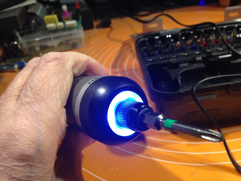 Osoba trzymająca elektryczny wkrętak z podświetleniem LED na końcówce.