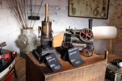 Zdjęcie przedstawia dwa modele maszyn parowych z kartkami informacyjnymi.