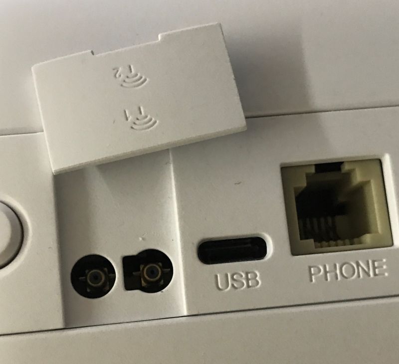 Zbliżenie na porty USB-C, telefoniczny RJ-11 i dwa złącza koncentryczne w białym urządzeniu