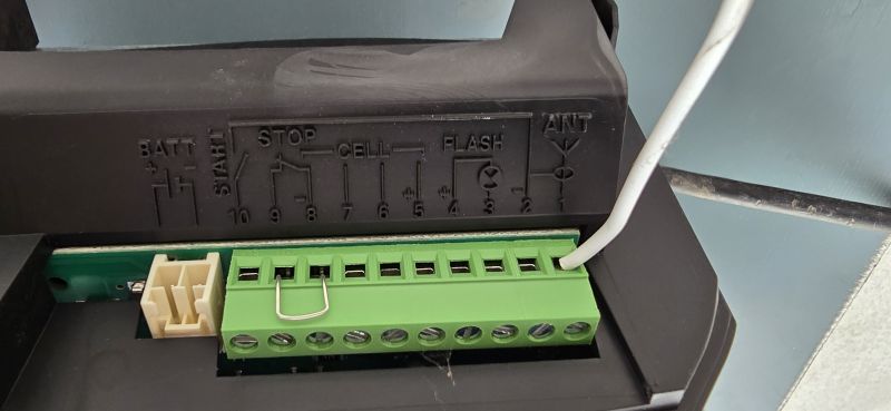 Zbliżenie listwy zaciskowej napędu bramy z opisami START, STOP, CELL, FLASH, ANT i numerami 10–2.