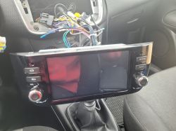 Radio samochodowe z systemem Android i odkrytymi kablami w samochodzie.