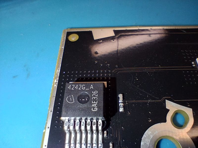 Nahaufnahme einer 4242G-A GAE326-IC auf einer schwarzen Leiterplatte (PCB).