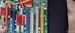 Zbliżenie na płytę główną z widocznymi slotami PCI, chłodzeniem i elementami elektronicznymi.