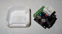 Electronic module with relay next to a white 3D-printed plastic enclosure