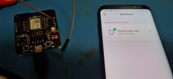 Microcontroller connected to a mobile device with an app screen showing device pairing.