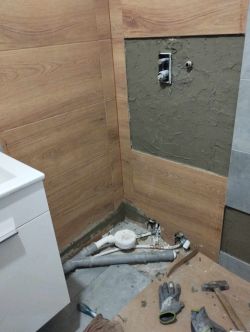 Instalacja elektryczna w łazience z widocznym przewodem przy posadzce.