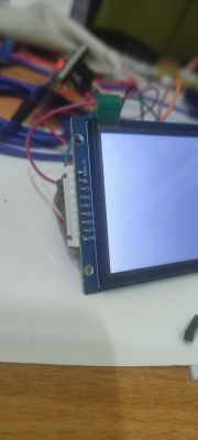 Zbliżenie na wyświetlacz LCD z podłączonymi przewodami i widocznymi pinami po lewej