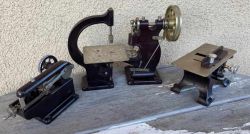 Modele miniaturowych maszyn ślusarskich i stolarskich na drewnianej powierzchni.