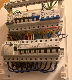 Rozdzielnica elektryczna z trzema rzędami wyłączników i skrupulatnym okablowaniem
