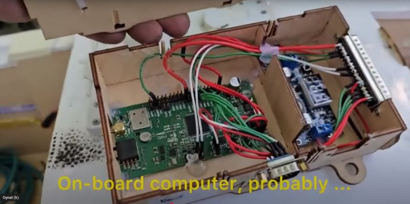 Komputer pokładowy z zieloną płytką PCB, przewodami i złączami w drewnianej obudowie