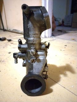 Gaźnik do silnika Briggs 8hp leżący na podłodze, widok z przodu.