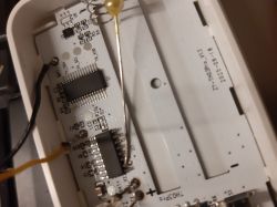 Inside a device: PCB with ICs and a two-AA battery compartment with a metal spring contact.