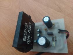 Płytka PCB z czarnym transformatorem UNITRA TELPOD GML-026/2 i kondensatorami na tle drewnianego blatu