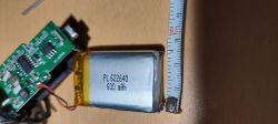 Akumulator litowo-polimerowy PL 622640 600 mAh obok płytki elektronicznej i miarki.
