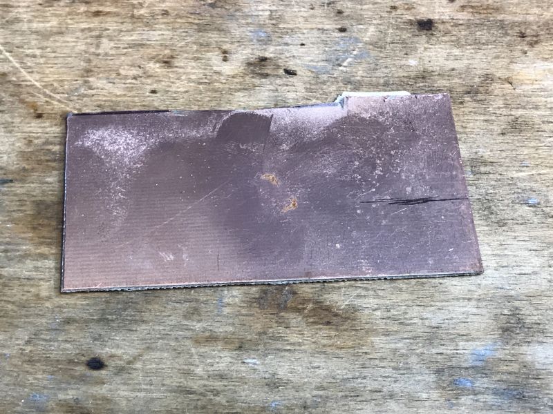 Copper Plate Before Mounting Preparation Copper plate on a wooden background.