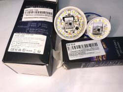 Two LED bulbs with visible electronic circuits next to their packaging.