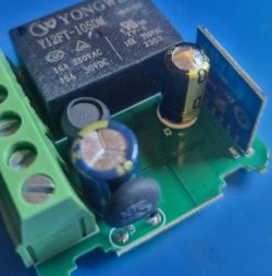Close-up of an electronic board with a relay and capacitors.