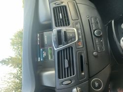 Panel środkowy samochodu z wyświetlaczem systemu multimedialnego R-Link, przyciskami klimatyzacji i radiem.
