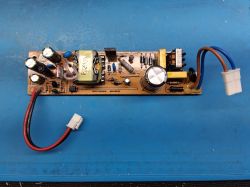 Płytka przetwornicy z elementami elektronicznymi, widoczna na niebieskim podkładzie.