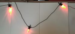 A string of lights with red and green pepper-shaped bulbs.