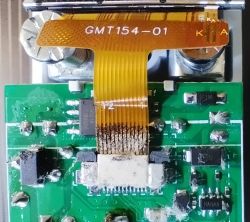 Close-up of a circuit board with an attached ribbon cable labeled GMT154-01.