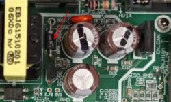 Zbliżenie na płytkę PCB z zaznaczoną diodą i trzema kondensatorami elektrolitycznymi.