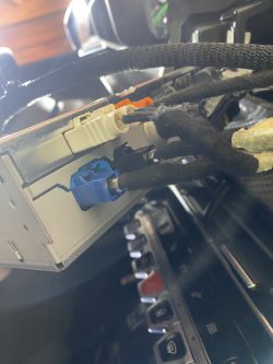 Zbliżenie na konsolę samochodową z kablami podłączonymi do tyłu ekranu LCD.