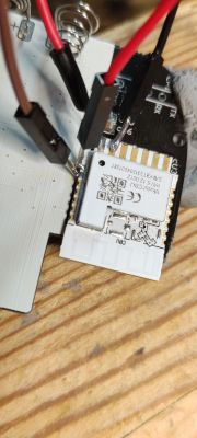 Close-up of an electronic module with wires and soldered connections.