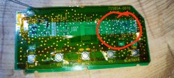 Płytka elektroniczna z głośnika Bose SoundLink Mini II z oznaczeniami i czerwonym okręgiem wskazującym miejsce zalania.