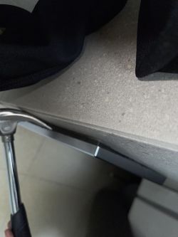 Zdjęcie przycisku Geberit do spłuczki i młotka na blacie.