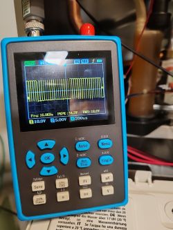 Blue handheld oscilloscope displaying a PWM signal waveform and measurement data