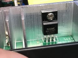 Zbliżenie na diodę Schottky'ego NAMC MBRF20200CT zamontowaną na radiatorze wewnątrz urządzenia elektronicznego.
