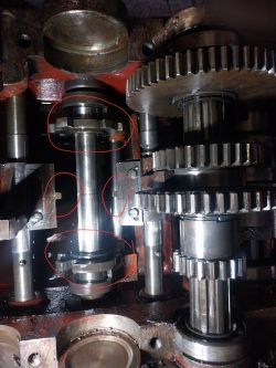 Wnętrze mechanizmu tokarki TUD 40 z widocznymi częściami przekładni, kołami zębatymi i zaznaczonym na czerwono wybierakiem biegów.