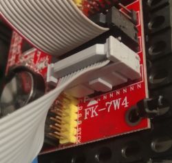 Zbliżenie na płytkę sterownika FK-7W4 z podłączoną taśmą.