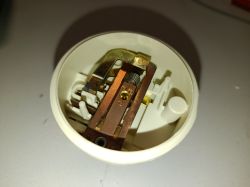 Wnętrze mechanicznego presostatu z widoczną sprężyną i stykami elektrycznymi
