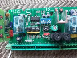 Zbliżenie na płytkę drukowaną z różnymi komponentami elektronicznymi, w tym kondensatorami, rezystorami i przekaźnikami, oznaczoną jako ZBX7-4-78.