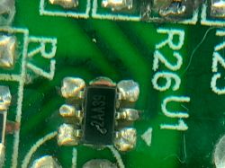 Zbliżenie na układ scalony z kodem 2AA39 na płytce drukowanej ładowarki.