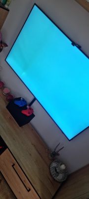 Telewizor QLED Samsung z białymi plamami widocznymi na niebieskim tle ekranu