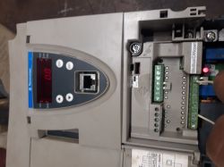 Panel sterownika z wyświetlaczem „0.0” i otwartą komorą zacisków z modułem Modbus/CANopen