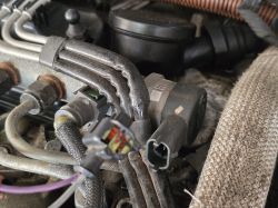 Zbliżenie na przewody silnika i czujnik ciśnienia paliwa w samochodzie