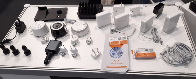 Stół wystawowy z ładowarkami i akcesoriami elektrycznymi na targach elektroniki.